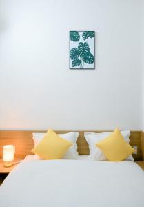 a bedroom with a white bed with yellow pillows at Familia Hotel in Hue