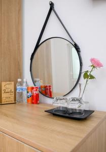 a mirror on a dresser with a vase and glasses at Familia Hotel in Hue