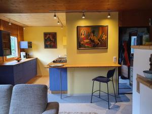 eine Küche mit gelben Wänden und einer Theke in einem Zimmer in der Unterkunft Gemütliches Ferienhaus mit grossem Garten, ideal für Naturliebhaber in Gerhardshofen