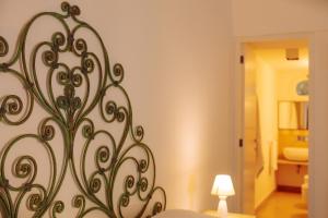a bedroom with a bed with a metal art on the wall at Villa Romasi in Leuca +37 photos