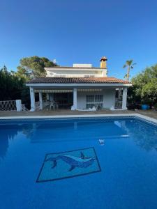 a large swimming pool with a house in the background at Villa Mis 5 Amores con piscina in Benidorm
