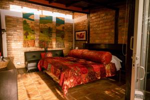 a bedroom with a bed and a brick wall at Posada la Serena in Villa de Leyva