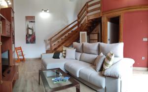 a living room with a couch and a staircase at Apartamentos El Sol in Potes