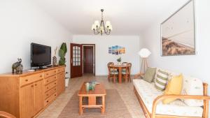 uma sala de estar com um sofá e uma televisão em Altura Vacations T2, Algarve em Altura