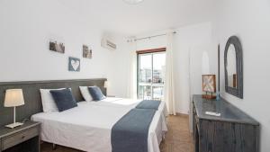 a bedroom with a large bed and a window at Altura Vacations T2, Algarve in Altura +5 photos