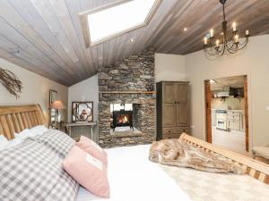 a bedroom with a bed and a stone fireplace at The Hare's Shack in Kendal