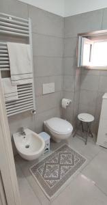La salle de bains blanche est pourvue d'un lavabo et de toilettes. dans l'établissement CASA VACANZE DIMORA MONFALCONE, à Montescaglioso