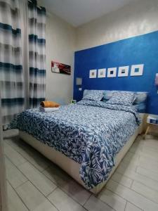 a bedroom with a bed with a blue and white comforter at Il Rifugio dei Colonna casadolcecasa in Marino
