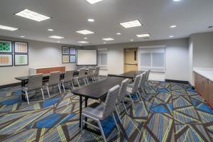 una sala de conferencias con mesas, sillas y una pizarra en Holiday Inn Express Hotel & Suites Talladega, an IHG Hotel, en Talladega