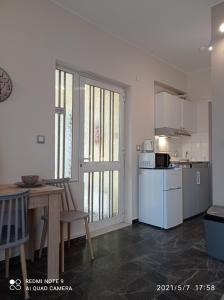 uma cozinha com uma mesa e um frigorífico branco em Sunshine Apartments em Kato Daratso