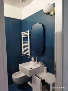 Un baño azul con lavabo y espejo. en Oltremare Numana, en Numana 28 fotos más