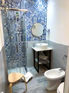 een badkamer met een wastafel, een toilet en een spiegel bij B&B Civico 20 in Palermo