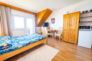 a bedroom with a bed and a kitchen at Apartamenty i pokoje Seeblick in Mikołajki