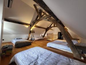 a bedroom with two beds in a room with beams at Villa 10 pers à 6min du pal in Saint-Pourçain-sur-Besbre