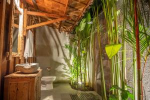 a bathroom with a toilet and plants on the wall at Bajalo Cottage Canggu - Adults only in Canggu +89 photos