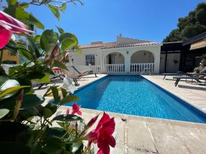 a swimming pool in front of a house at Villa la Vida in L’Alfàs del Pi