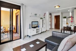 een woonkamer met een bank en een tv bij LOVELY MOCAN, Pool, Fast Wi-Fi, Padel Court in Palm-mar
