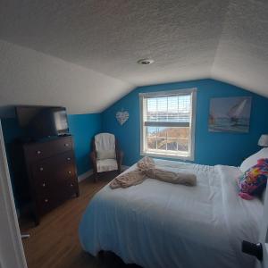 - une chambre bleue avec un lit et une télévision dans l'établissement Starboard Side Guest House, à Channel-Port-aux-Basques