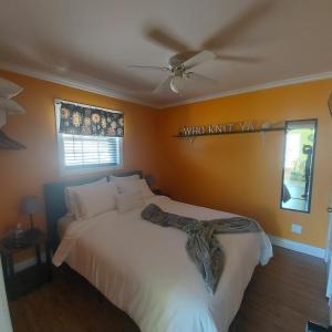 - une chambre avec un lit blanc et un ventilateur de plafond dans l'établissement Starboard Side Guest House, à Channel-Port-aux-Basques