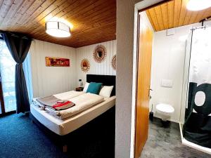 a small bedroom with a bed and a toilet at Hôtel Restaurant Les Cernets, "Val-de-Travers" in Les Verrières +288 photos