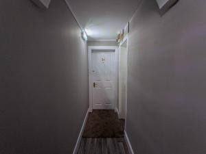 a hallway with a white door and a light at Beautiful Spacious Central Flat, Pitlochry in Pitlochry