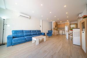 salon z niebieską kanapą i stołem w obiekcie HomeHolidaysRentals Benoit - Costa Barcelona w mieście Pineda de Mar