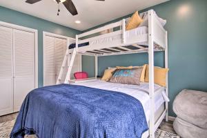 a bedroom with a white bunk bed and a chair at Walk to Maryland Beach Canal-Front Escape with Dock in Ocean City
