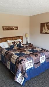 um quarto com uma cama com um cobertor em Dwight Village Motel em Dwight