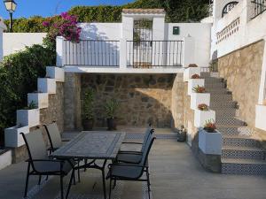 un patio con mesa, sillas y escaleras en Cozy Spanish house in Nueva Andalucia Golf Padel Hiking and Sun, en Marbella