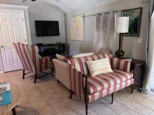 ein Wohnzimmer mit einem Sofa und einem TV in der Unterkunft Private Villa with outside garden walk to the bay and Ringling Museum minutes from downtown in Sarasota