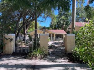 ein Tor vor einem Haus mit einer Palme in der Unterkunft Private Villa with outside garden walk to the bay and Ringling Museum minutes from downtown in Sarasota