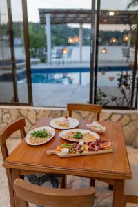 una mesa de madera con platos de comida. en Hotel Sabana, en Flores