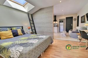 a bedroom with a bed and a living room at Aux Matins du Bonheur in Surzur