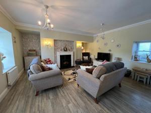 a living room with two couches and a fireplace at May Bell Cottage in Dersingham