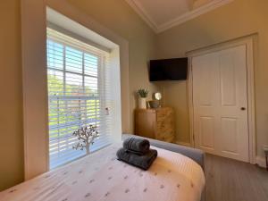 a bedroom with a bed with a towel on it at May Bell Cottage in Dersingham