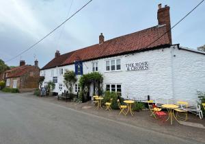 a white building with tables and chairs in front of it at May Bell Cottage in Dersingham