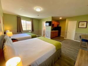 um quarto de hotel com duas camas e uma cozinha em Europa Inn & Suites em Desert Hot Springs
