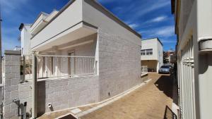 a white brick building with a balcony on a street at La Resilienza in Ginosa Marina +7 photos