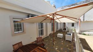 a patio with an umbrella and chairs and a table at La Resilienza in Ginosa Marina