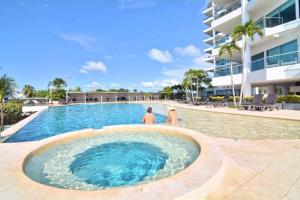 two people standing in a swimming pool next to a building at Apartamento Cartagena Alquiler - Edif Seaway 935 in Cartagena de Indias