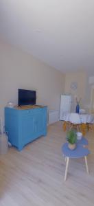 uma sala de estar com um armário azul e uma mesa em L'Escale Bretonne 4 personnes, proche mer, jardin privé clos et indépendant, appartement en rez de chaussé em Le Guilvinec