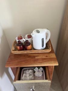 Cosy double room with private bathroom homestay في Caldecote: رف خشبي عليه صانع قهوة