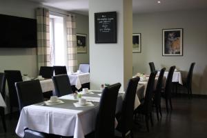 ein Esszimmer mit Tischen und Stühlen und einer Tafel in der Unterkunft Hôtel Burgevin in Sully-sur-Loire
