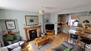 a living room with a couch and a fireplace at Deeside Holiday Cottages in Dinnet