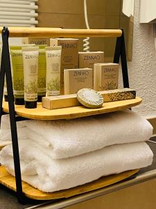 un estante con toallas y otros productos. en Hôtel Casa 49 en Remich