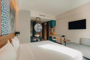 een hotelkamer met een bed en een televisie bij Occidental Tanger in Tanger