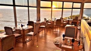 a restaurant with tables and chairs and a view of the ocean at Watersmeet Hotel in Woolacombe