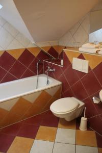 a bathroom with a toilet and a tub and a sink at Waldhaus Colditz Garni in Colditz