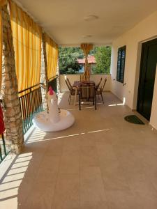 a patio with a table and chairs on a balcony at Apartment House Zdrelac - Meri in Ždrelac