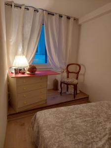 een slaapkamer met een bed, een stoel en een raam bij Campitelli view in Rovinj